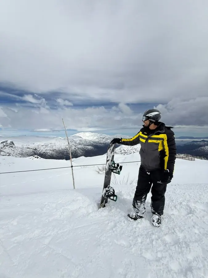 Snowboarder looking out over the snow-capped Andes