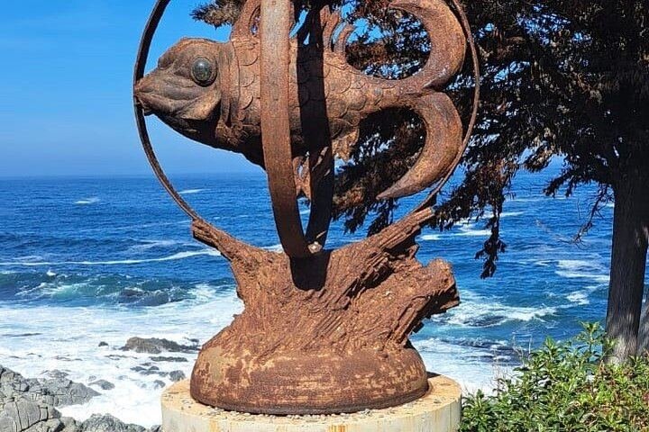 Rusty metal fish sculpture facing the sea