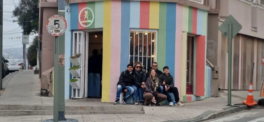 Family sitting on a colorful corner in Valparaíso