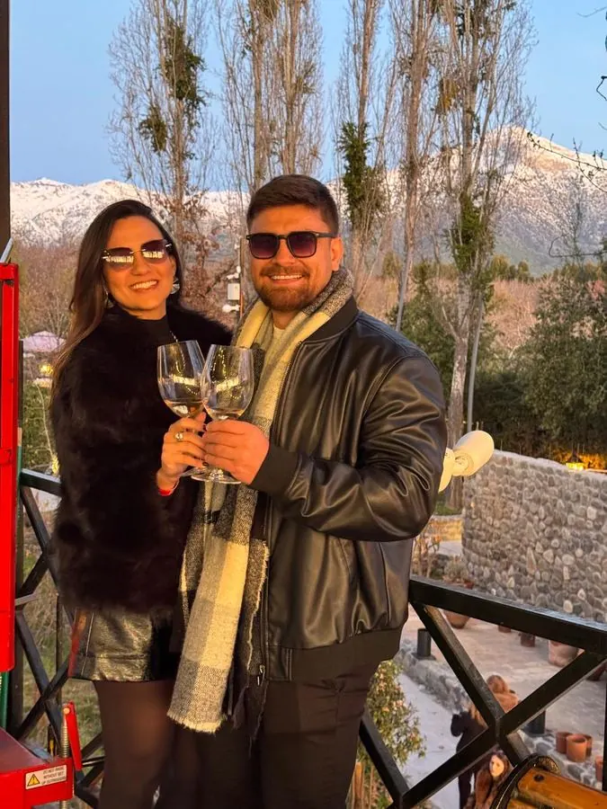 Couple toasting with wine in front of the snow-capped Andes at a winery