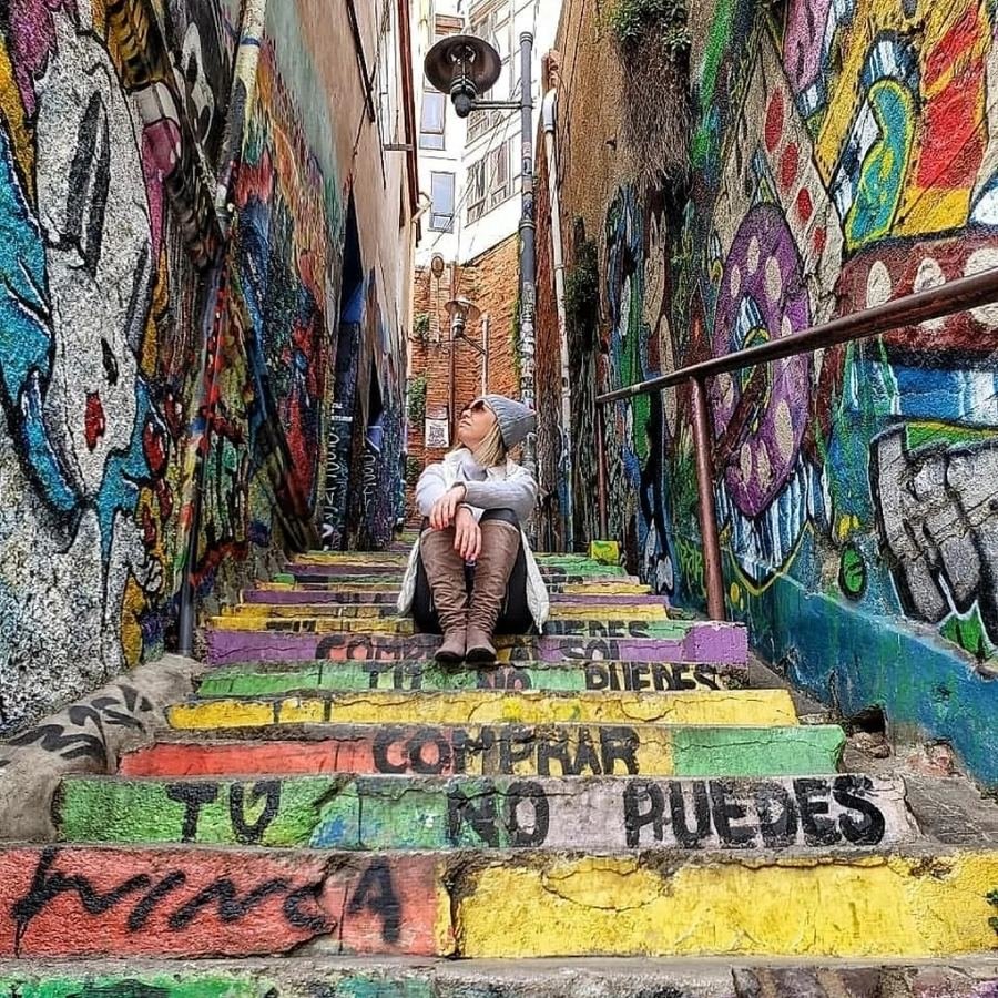 Traveler sitting on a graffiti-covered staircase in Valparaíso