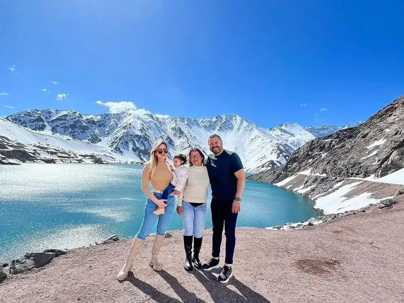 Family in front of Embalse El Yeso with turquoise water and the snow-capped Andes