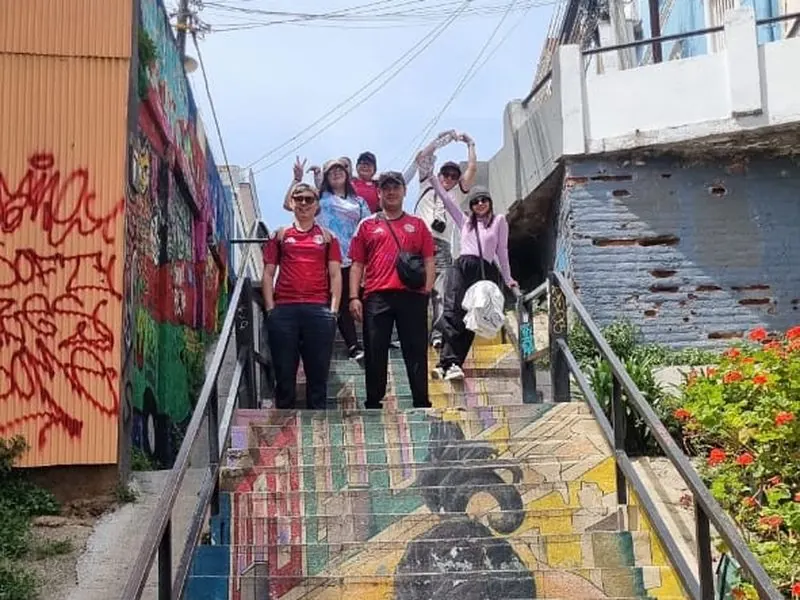 Travelers on a giant mural staircase in Valparaíso, Chile