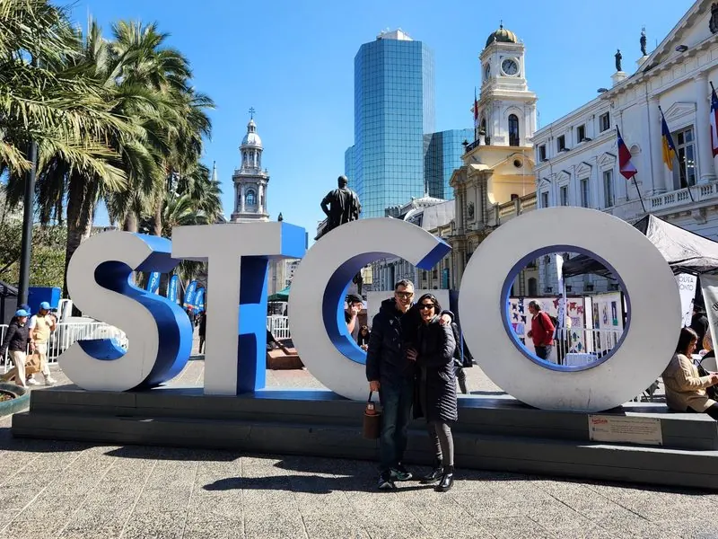 Travelers in front of the STGO sign in Plaza de Armas, Santiago, Chile